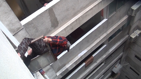 น่าหวาดเสียว! คนชราวัย 74 ปีพลัดตกระเบียงห้อยค้างบนตึกสูง